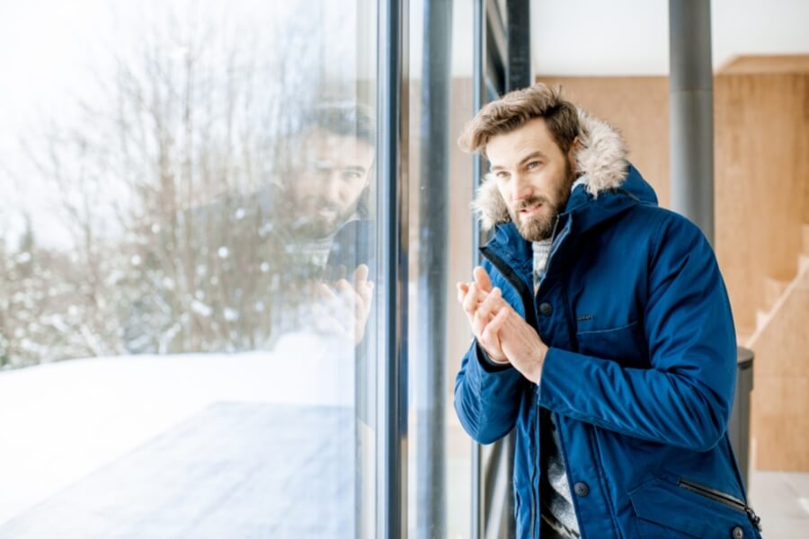Homeowner feeling cold indoors near window due to heating issue