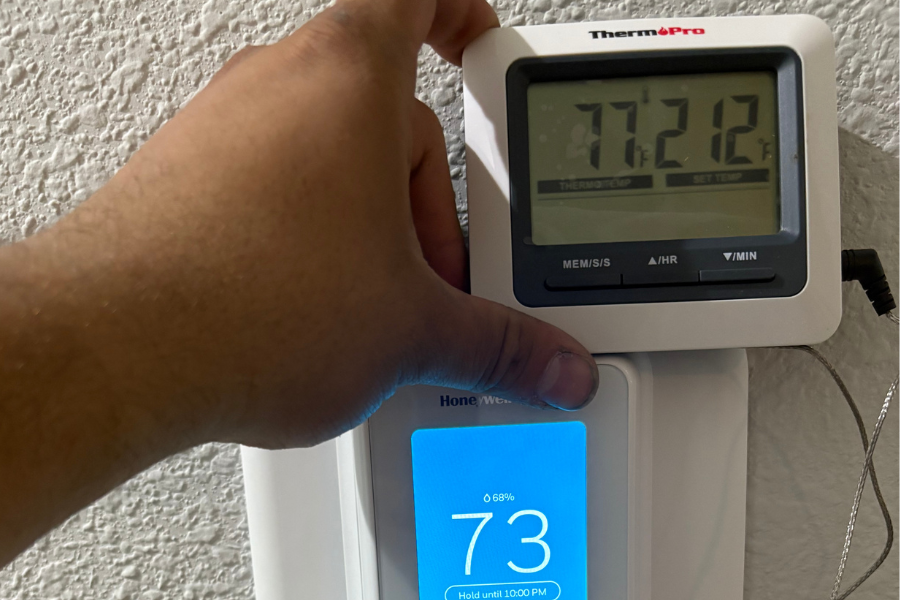 Technician calibrating an AC system and thermostat to ensure the correct indoor temperature.