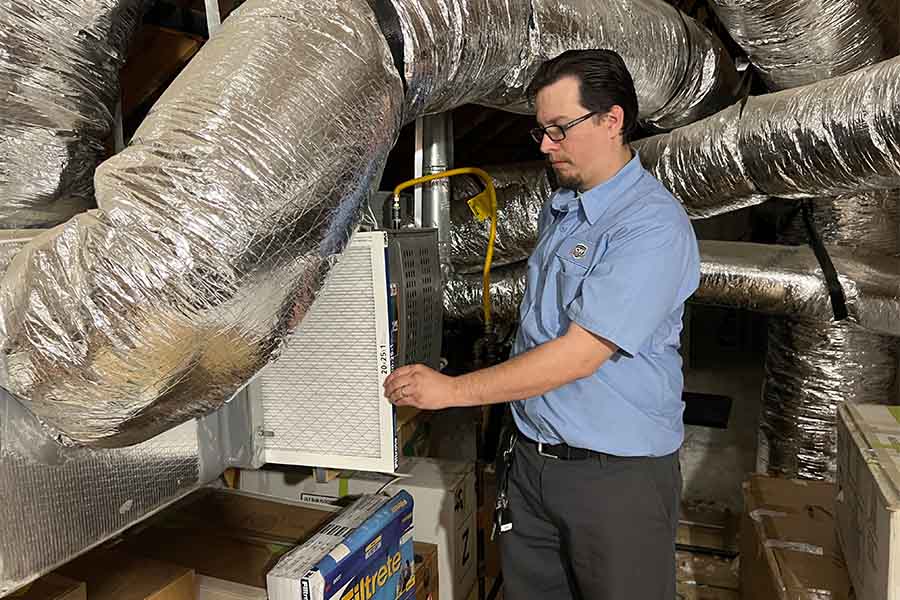 HVAC technician installing new air filter