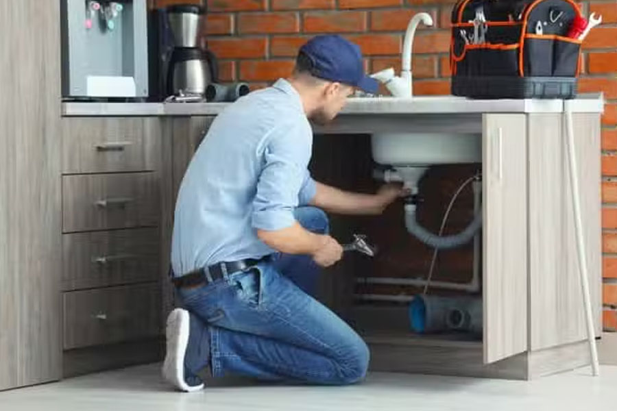Under-sink plumbing repair performed by licensed plumber
