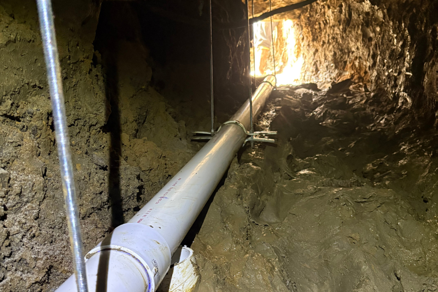 Friendly CW Service Pros plumber smiling during a residential sewer line slab leak repair in Frisco, TX.