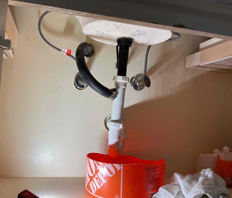 Plumbing repair under bathroom sink with drain pipes in Lewisville TX