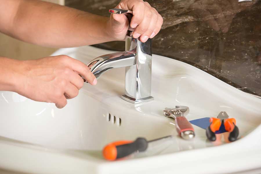 CW Service Pros plumber repairing a bathroom faucet in The Colony TX