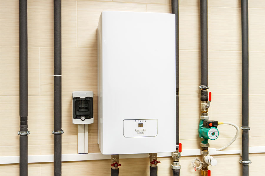 Tankless water heater mounted on wall with connected plumbing lines