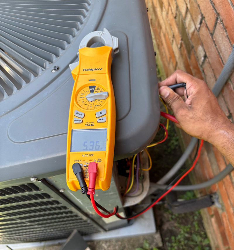 CW Service Pros technician testing heat pump system during repair in Prosper TX