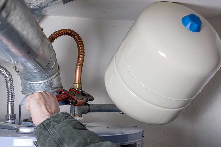 Water heater repair in progress with expansion tank connection adjustment in Grapevine
