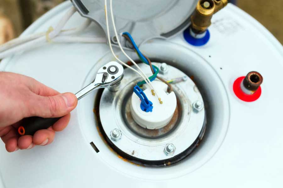 Technician repairing water heater element and wiring connections
